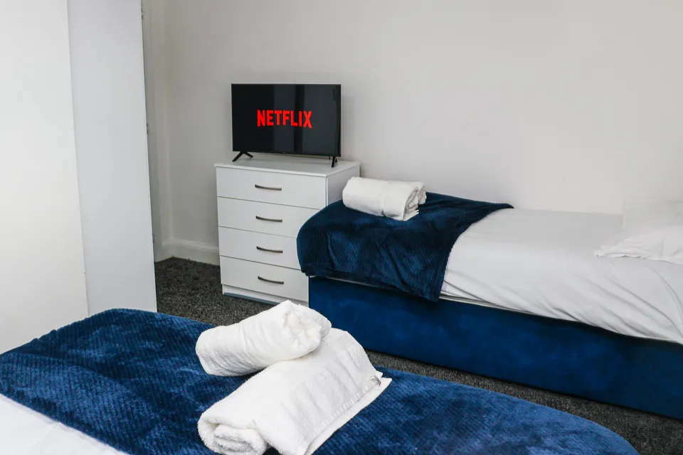 Bedroom at Humber Hub with navy throws and rolled towels