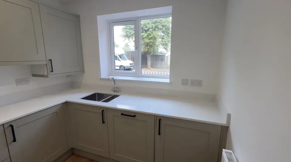 Fitted kitchen with a white worktop and a window