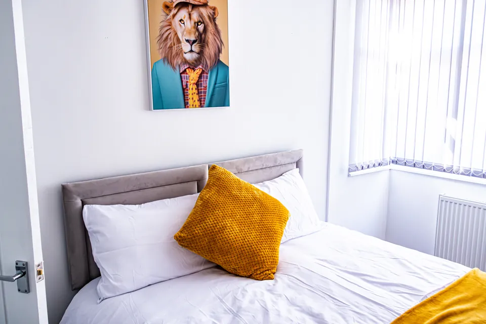 Double bedroom at Sullivan Heights with a mustard cushion and a framed print